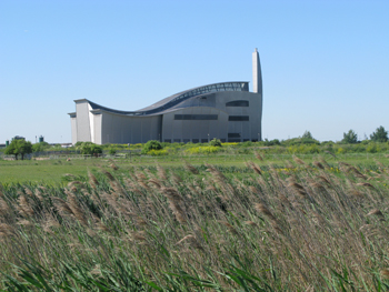 A photograph of a silver building on some marshland