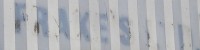 Photograph of a faded shop sign. The sign has vetical blue and light blue stripes. The word 'Frakes' is just visable. 